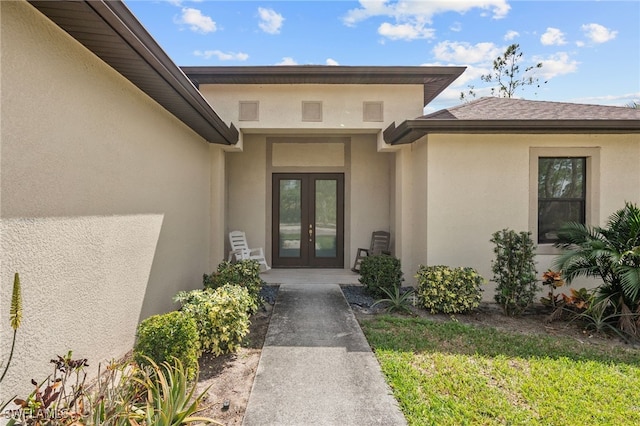 doorway to property featuring french doors and stucco siding