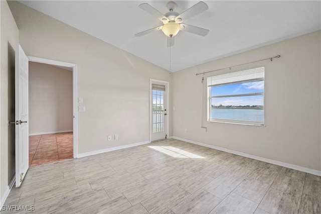 unfurnished room with lofted ceiling, a ceiling fan, and baseboards