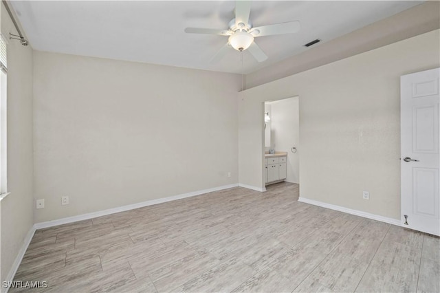 unfurnished bedroom featuring visible vents, ensuite bathroom, light wood-type flooring, and baseboards