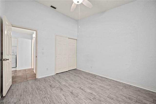 unfurnished bedroom featuring visible vents, washer / dryer, ceiling fan, and wood tiled floor