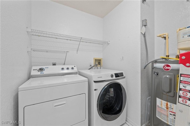 washroom featuring washer and dryer, electric water heater, and laundry area