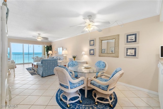 dining area featuring light tile patterned floors, baseboards, ornamental molding, and a ceiling fan