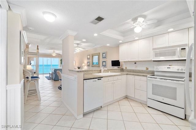 kitchen featuring white appliances, visible vents, ornamental molding, a sink, and open floor plan