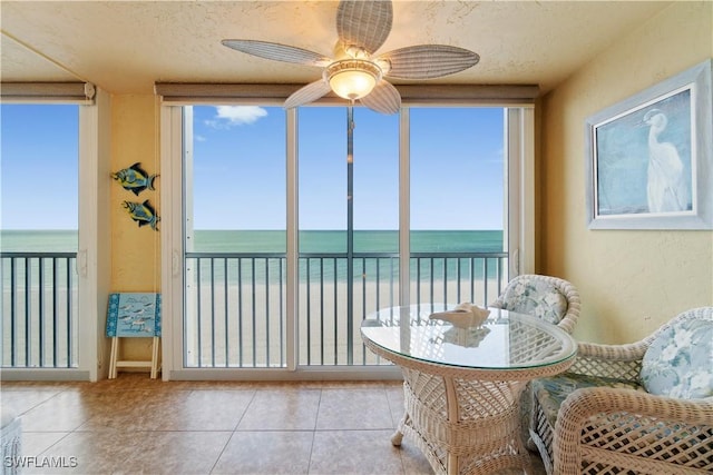 sunroom with a water view and ceiling fan