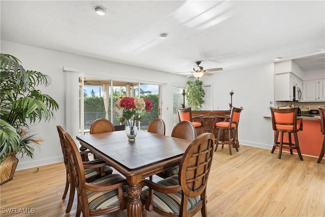 dining area with light wood-style floors, baseboards, and a ceiling fan