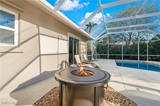 view of patio with a lanai, an outdoor fire pit, and an outdoor pool