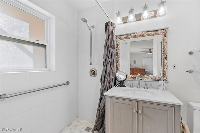 full bath featuring a tile shower, vanity, and toilet