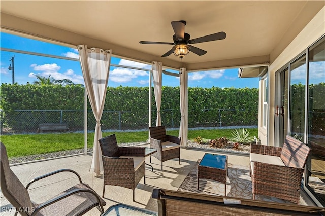 sunroom / solarium featuring a ceiling fan