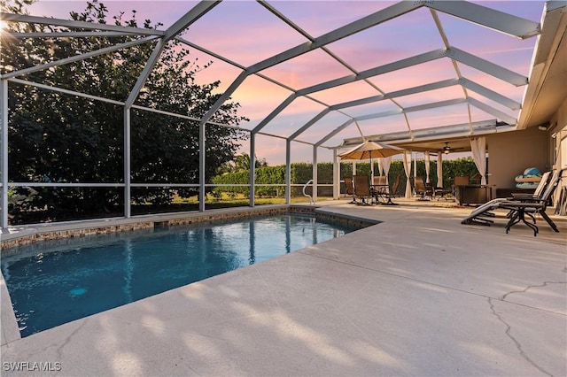 outdoor pool featuring a patio and glass enclosure