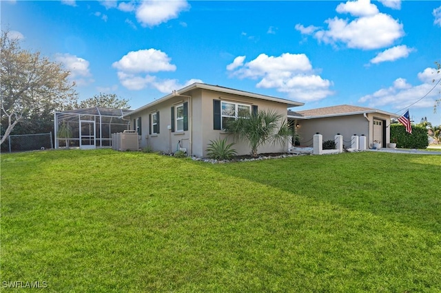 view of side of home featuring a lanai, a yard, an attached garage, and stucco siding