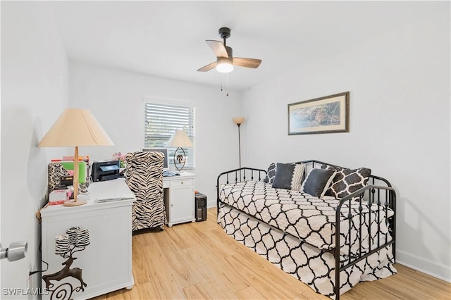 bedroom featuring ceiling fan, light wood-style flooring, and baseboards