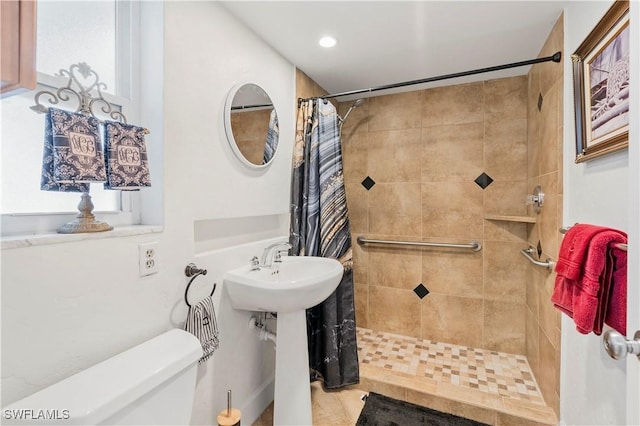 full bath with tiled shower, a sink, and toilet