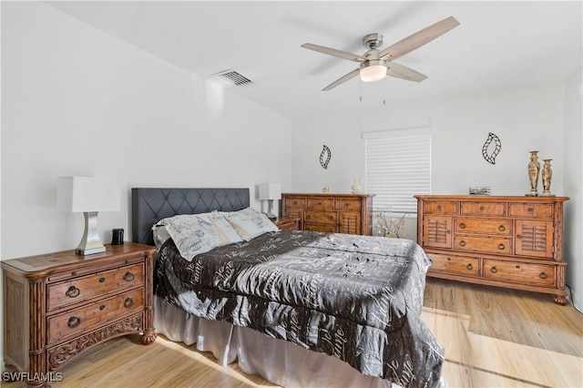 bedroom featuring light wood-style floors, visible vents, and a ceiling fan