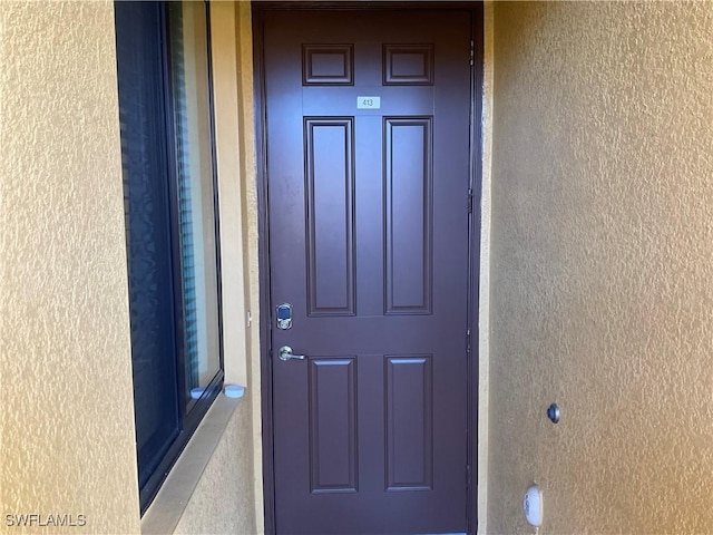 property entrance featuring stucco siding