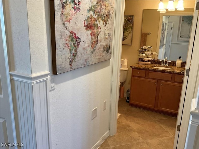 bathroom with toilet, tile patterned flooring, and vanity