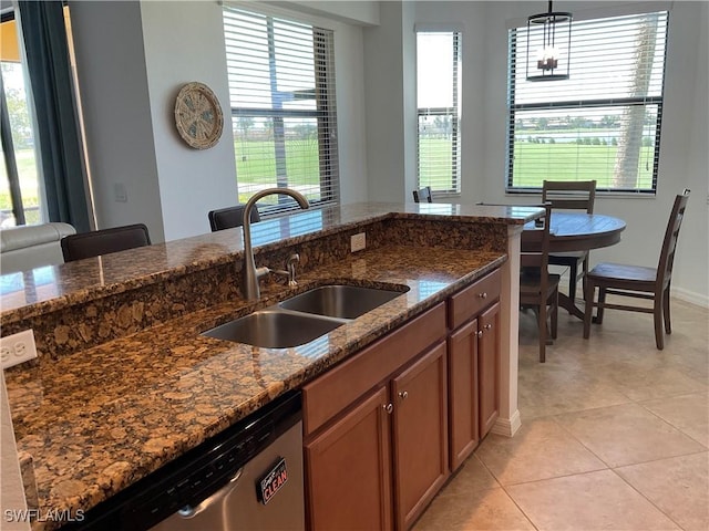 kitchen featuring a healthy amount of sunlight, a sink, hanging light fixtures, and dishwasher