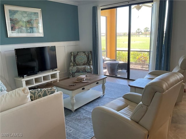 tiled living area featuring a decorative wall and wainscoting