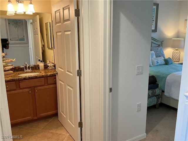 ensuite bathroom with a chandelier, tile patterned flooring, vanity, and ensuite bath