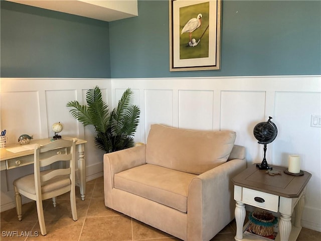 sitting room with a wainscoted wall and light tile patterned floors