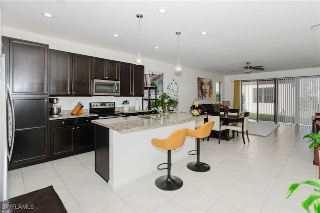 kitchen with a breakfast bar area, light stone counters, visible vents, recessed lighting, and appliances with stainless steel finishes