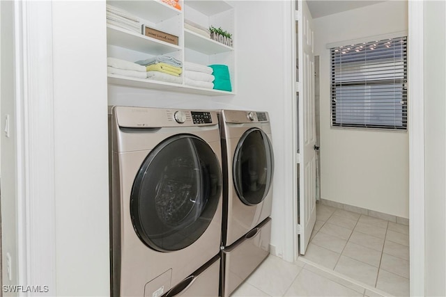 laundry area with laundry area, light tile patterned flooring, baseboards, and washer and clothes dryer