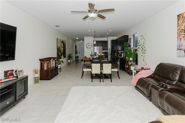 living room featuring light tile patterned floors, visible vents, and a ceiling fan