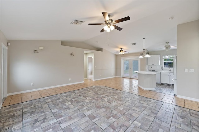 unfurnished living room featuring visible vents, baseboards, french doors, and vaulted ceiling