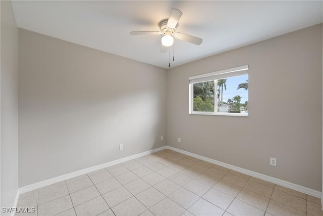 spare room featuring baseboards, ceiling fan, and light tile patterned flooring