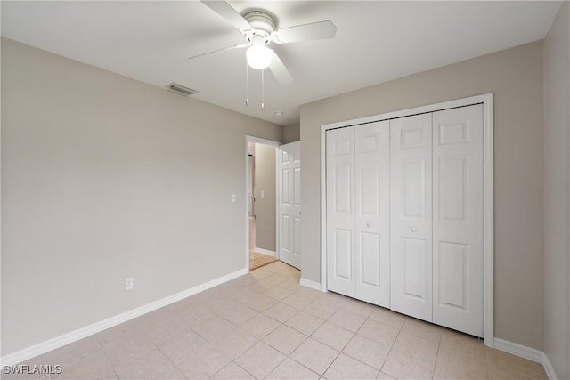 unfurnished bedroom featuring light tile patterned floors, visible vents, baseboards, ceiling fan, and a closet