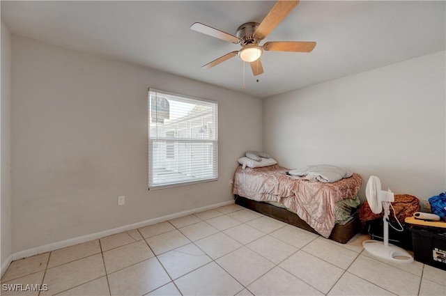 bedroom with light tile patterned floors, ceiling fan, and baseboards