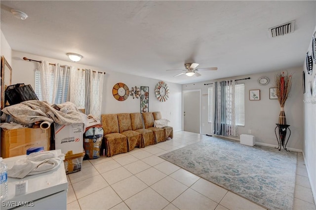 living area featuring light tile patterned floors, visible vents, and ceiling fan