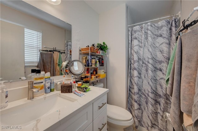 bathroom featuring a shower with curtain, toilet, and vanity