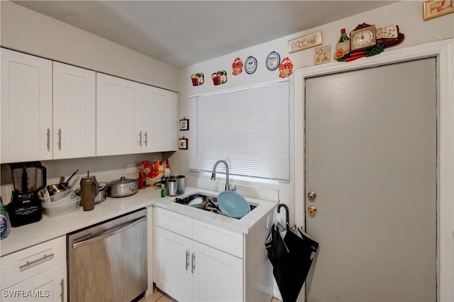 kitchen with a sink, white cabinets, light countertops, and stainless steel dishwasher