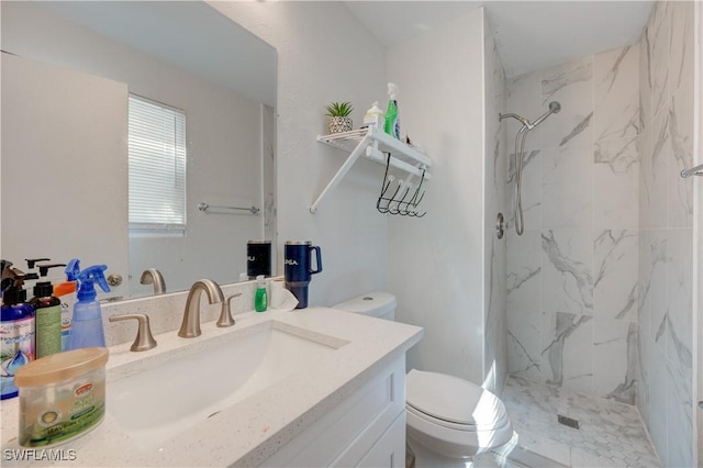 bathroom featuring a marble finish shower, toilet, and vanity