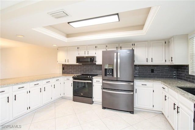 kitchen featuring visible vents, a tray ceiling, black / electric stove, stainless steel fridge with ice dispenser, and light stone countertops