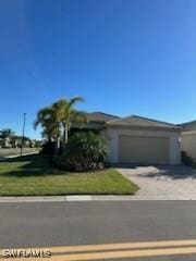 view of front of house featuring driveway, a garage, and a front lawn