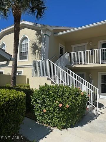 exterior space featuring stairs and stucco siding