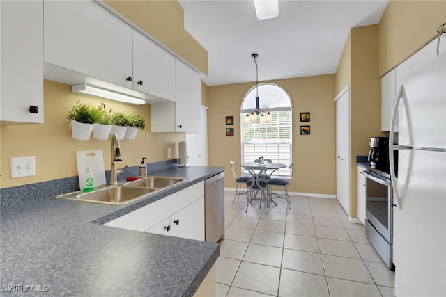 22741 Sandy Bay Dr Unit 201, Estero, FL 33928 - kitchen with light tile patterned floors, a sink, stainless steel appliances, white cabinetry, and dark countertops