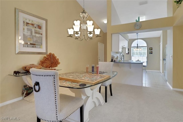 22741 Sandy Bay Dr Unit 201, Estero, FL 33928 - dining space featuring an inviting chandelier, light tile patterned floors, baseboards, and light carpet