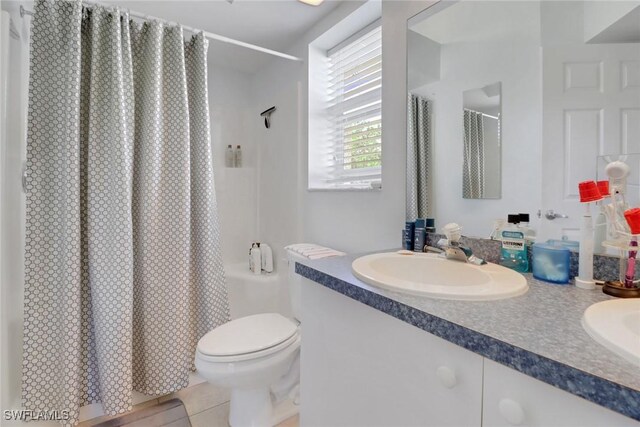 22741 Sandy Bay Dr Unit 201, Estero, FL 33928 - bathroom with a shower with shower curtain, toilet, double vanity, and a sink