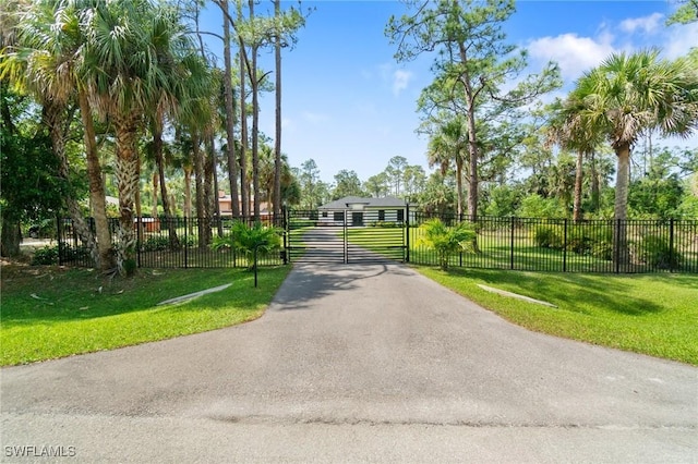 view of community featuring a gate, fence, and a yard