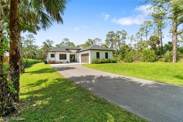 view of front of property with a garage, a front lawn, concrete driveway, and stucco siding