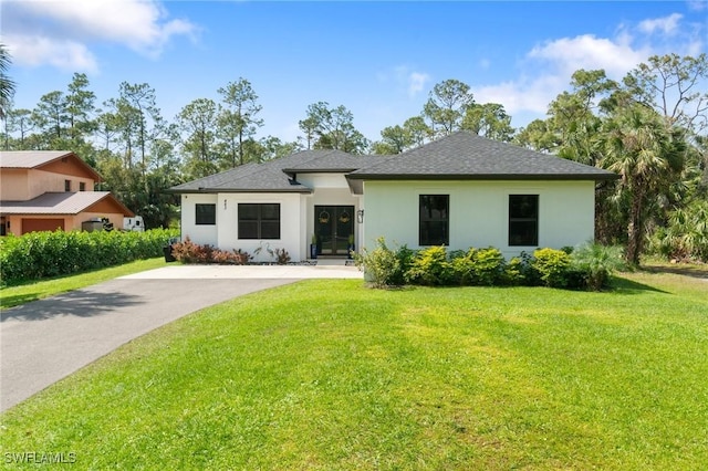 view of front of home featuring driveway, a shingled roof, a front yard, and stucco siding