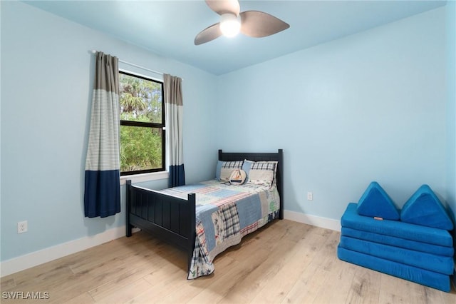 bedroom featuring ceiling fan, baseboards, and wood finished floors