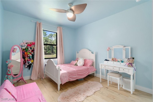 bedroom with a ceiling fan, baseboards, and wood finished floors