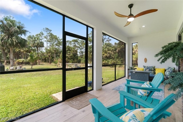 sunroom / solarium with a healthy amount of sunlight and ceiling fan