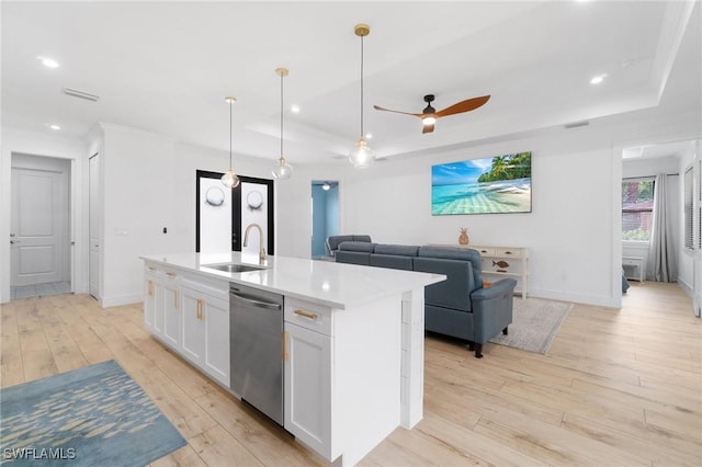 kitchen featuring visible vents, white cabinets, dishwasher, light wood-type flooring, and a sink