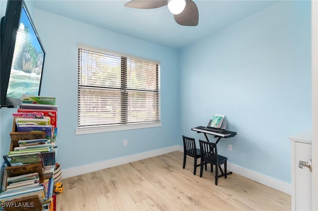 misc room with a ceiling fan, baseboards, and wood finished floors