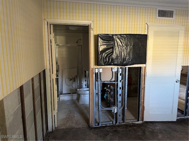 corridor featuring concrete flooring, visible vents, and wallpapered walls