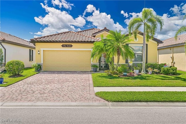 mediterranean / spanish home featuring a tiled roof, an attached garage, decorative driveway, a front lawn, and stucco siding